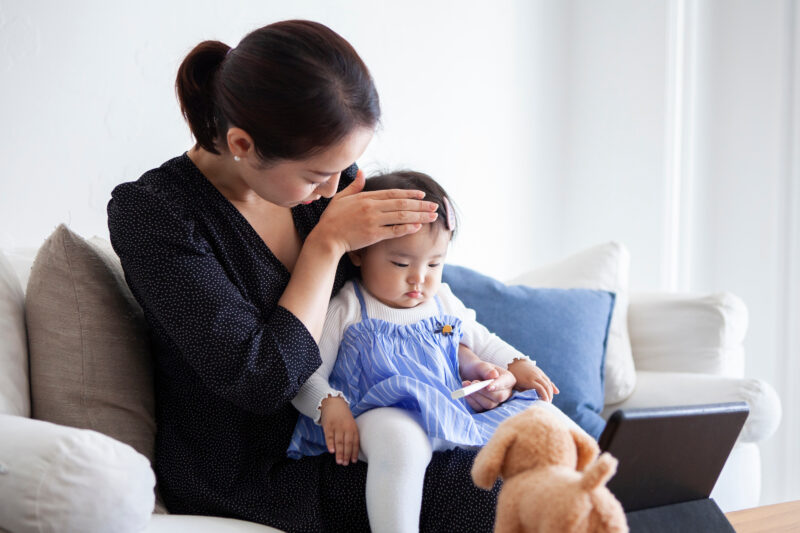 娘の発熱を気にする母親
